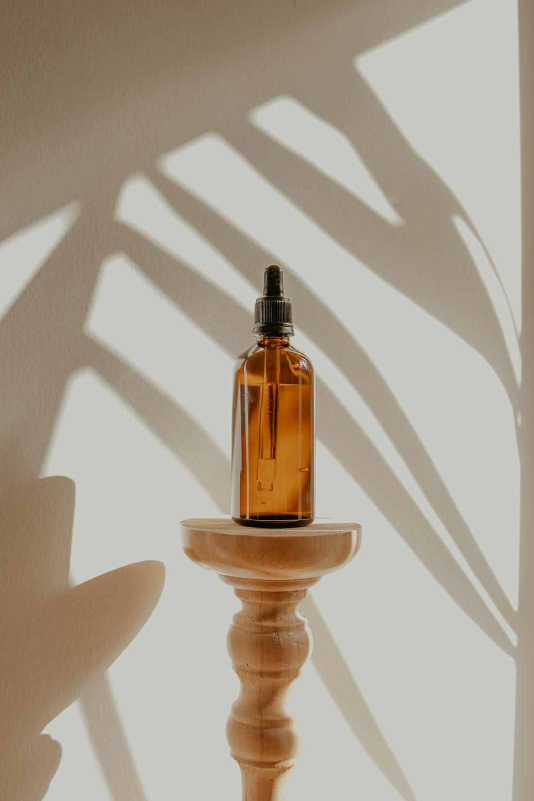 Amber botanical oil bottle in warm natural light